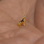 a small gold dog charm sitting on a persons hand