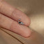 a person's hand holding a tiny silver bird ring