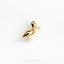 a gold bird brooch sitting on top of a white surface