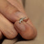 a woman&#39;s hand holding a tiny silver bow ring