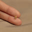 a person&#39;s hand holding a tiny gold ring
