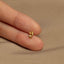 a person&#39;s hand holding a tiny gold ring