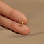 a person's hand holding a tiny gold ring
