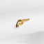 a golden gun pin sitting on top of a white cloth