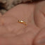 a tiny gold nose ring on someone's hand