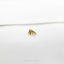 a pair of gold earrings sitting on top of a white surface