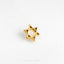 a gold star of david pin sitting on a white surface
