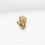 a gold hand brooch on a white background