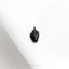 a small black object sitting on top of a white cloth