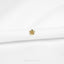 A small gold flower-shaped earring is displayed against a white background.