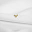 A small gold-colored charm with the text "DAD" engraved on it, placed on a white fabric surface.