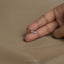 A close-up of a person's hand holding a small silver earring with three small diamonds.