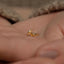 a small gold nose ring on a person's hand