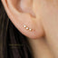 A close-up of a person's ear with a small gold star-shaped earring attached to the earlobe.