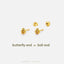 a pair of gold earrings with butterfly and ball-shaped designs, arranged on a white background.