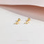 A pair of gold earrings with small white stones on a white background.