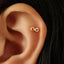 A gold earring with an infinity symbol is visible in the person's ear.