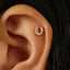 A gold earring with a small diamond in the center is visible in the person's ear.