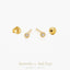 a pair of gold earrings with small diamonds, including a butterfly-shaped earring and a ball-shaped earring.