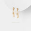 A pair of gold earrings with small diamonds hanging from the chain.