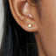 A close-up view of a person's ear with a small gold earring in it.