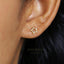 A close-up of a person's ear with a small gold star-shaped earring.