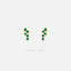 A pair of earrings with green gemstones, specifically emeralds, set in gold.
