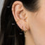 a close-up of a person's ear with multiple gold hoop earrings. The earrings are of different sizes, ranging from 6mm to 9mm, and are arranged in a row.