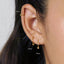 a close-up view of a person's ear with three gold hoop earrings attached. The earrings are labeled with their sizes in millimeters: 6mm, 8mm, and 10mm.