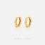 A pair of gold-colored earrings with hexagonal shapes, displayed against a white background.