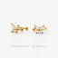 a pair of gold earrings with small, clear stones set in a delicate, flower-like design.