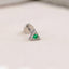 A silver earring with a green gemstone is shown against a light background.