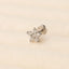 A single diamond-encrusted earring is shown against a light beige background.