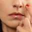 A close-up of a person's face, focusing on their lips and fingers.