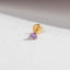 A gold-colored earring with a purple gemstone is shown against a white background.