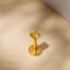 A single yellow gemstone, possibly a diamond, is the focal point of the image, set in a gold-colored metal earring.