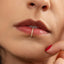 A close-up of a person's face, focusing on their lips and the gold ring on their lip.