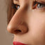 A close-up of a person's face, focusing on their nose and the gold nose stud.