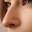 A close-up of a person's nose with a small, clear gemstone or piercing in it.