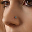 A close-up of a person's nose with a small blue gemstone nose ring.