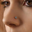 A close-up of a person's nose with a small blue gemstone nose ring.