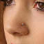 A close-up of a person's face, focusing on their nose and the small gold nose ring.