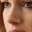 A close-up of a person's face, focusing on their nose and the small gold spider web-shaped nose stud.