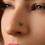 A close-up of a person's face, focusing on their nose and the green gemstone nose ring.