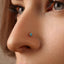 A close-up of a person's nose with a small turquoise-colored nose stud.