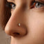 A close-up of a person's nose with a small, clear gemstone nose ring.