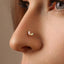 A close-up of a person's nose with a nose stud featuring a small, delicate flower-shaped stone.