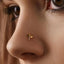 A close-up of a person's nose with a small gold-colored nose ring or stud.