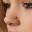 A close-up of a person's face, focusing on their nose and the gold-colored earring in their ear.