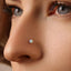 A close-up of a person's nose with a small, round, white stone or gemstone piercing.